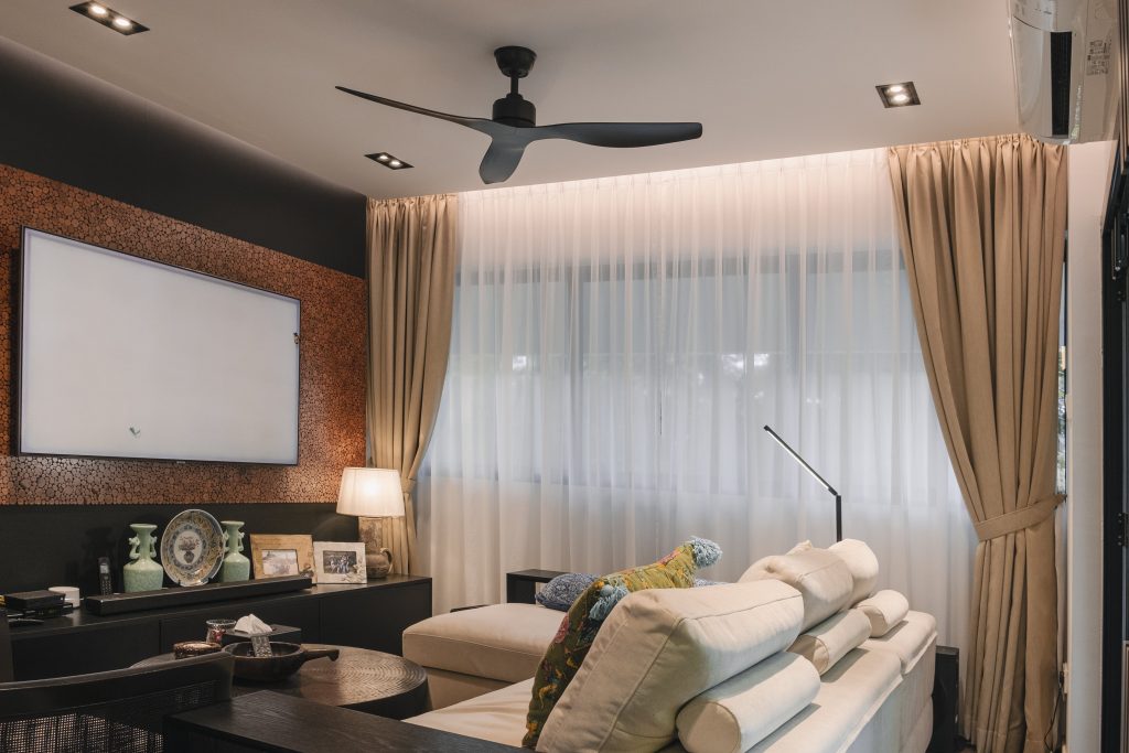 Beige curtains in a cosy Singapore living room with sheer day curtains, modern lighting, and a minimalist sofa.