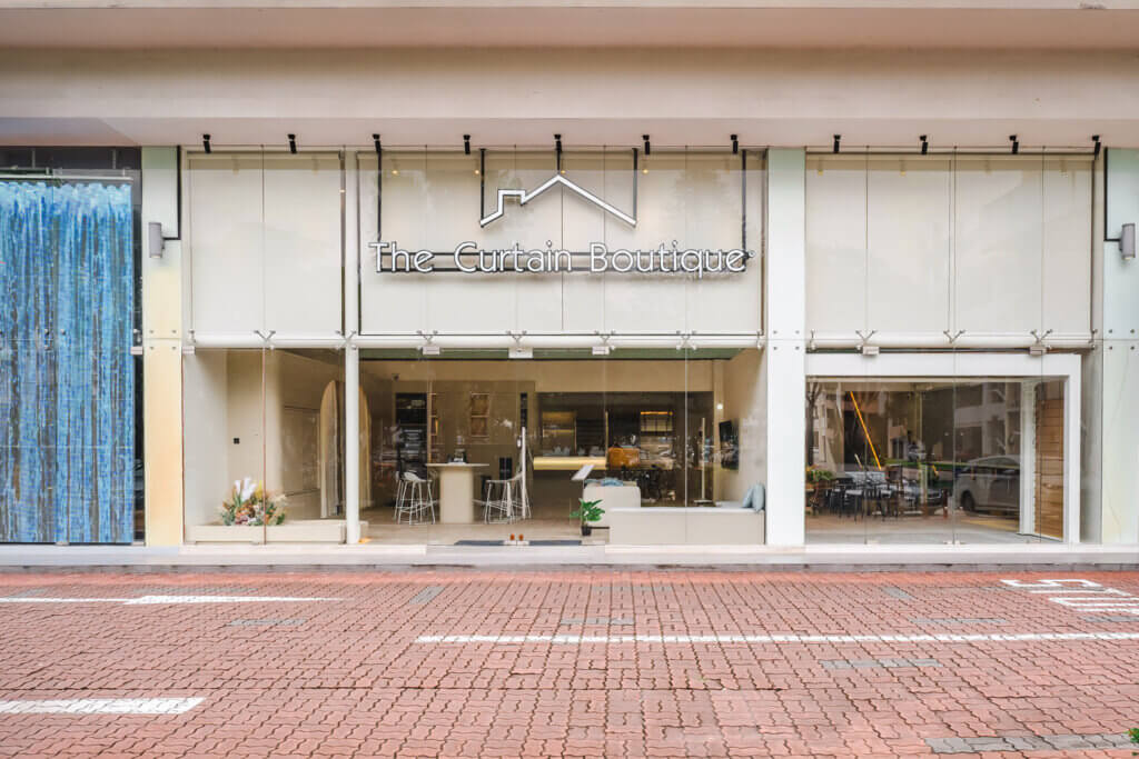 The Curtain Boutique showroom front at Vertex Ubi with a bright glass façade and brand signage in Singapore