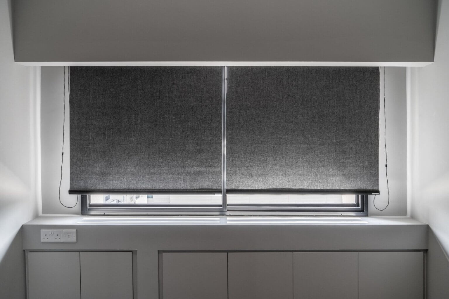 Blackout roller blinds installed in a Singapore bedroom without U-channels, showing light gaps at the sides and bottom