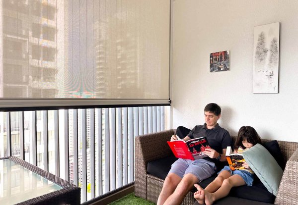 Ziptrak and Invisible Grilles in a condo balcony Ziptrak and Invisible Grilles in a condo balcony in Singapore with father and son reading